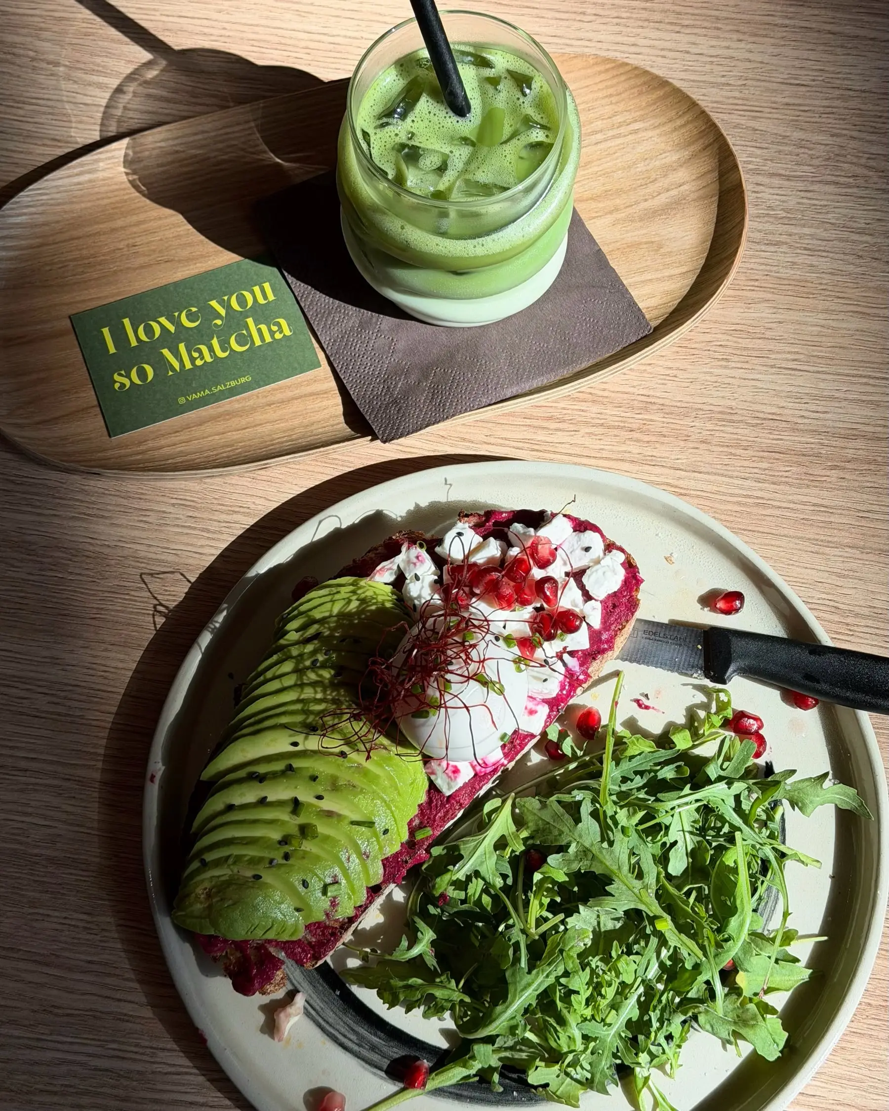 Sauerteigbrot mit Rote-Rüben-Aufstrich, Avocado und Granatapfel, dahinter ein Iced Matcha