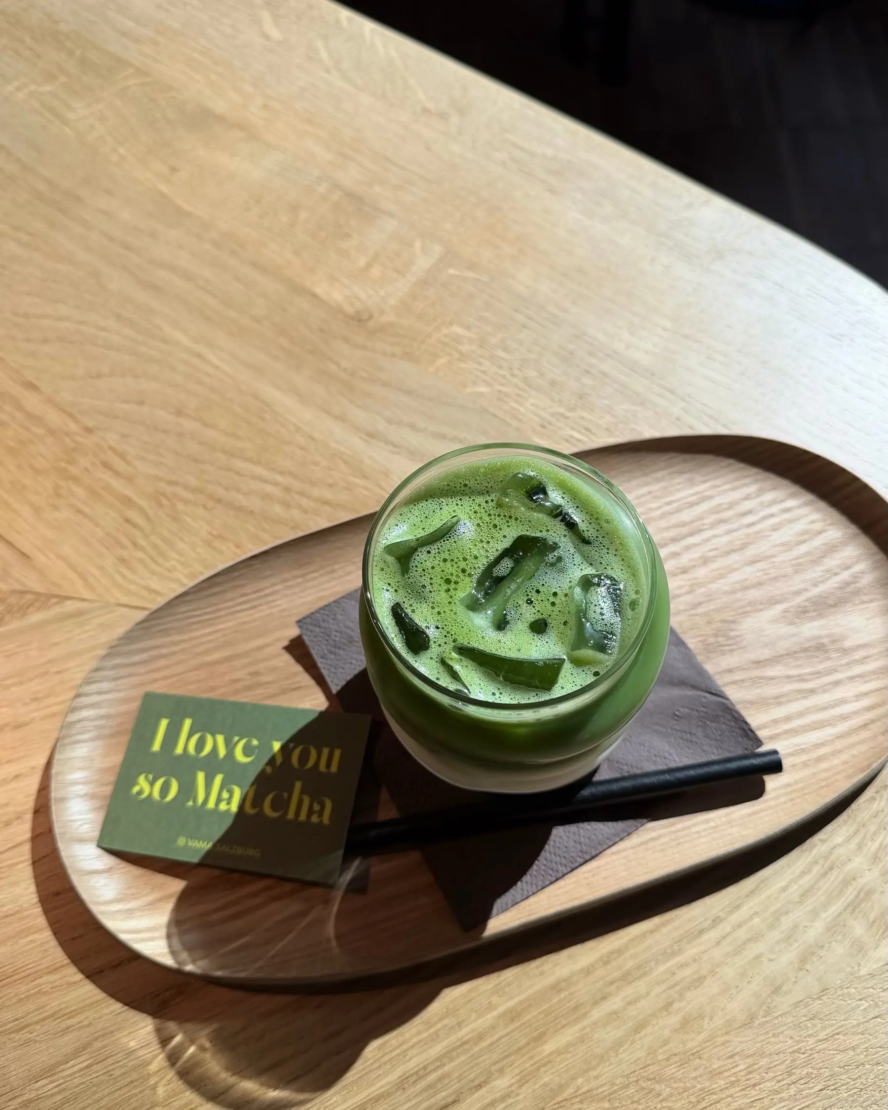 Iced Matcha Latte auf einem ovalen Holztablett, daneben die Karte „I love you so Matcha“